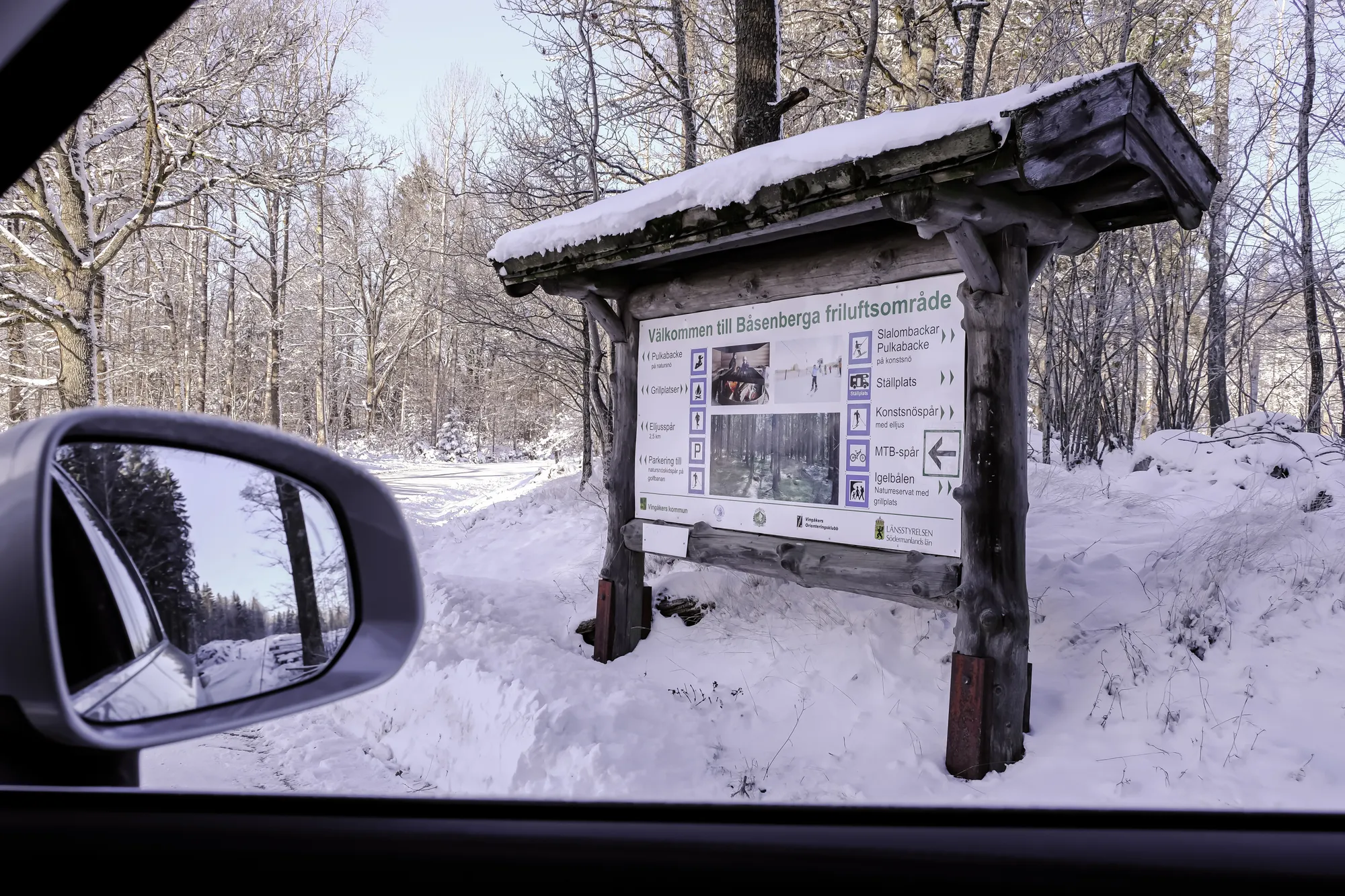 A snow-covered information board at Båsenberga recreation area.